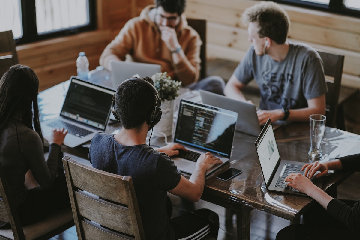 Professionals in a cohort discussion reviewing AI concepts together in a training room