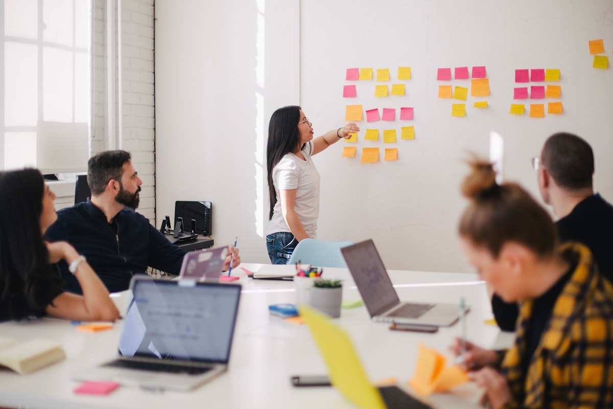 Manager reviewing an AI adoption curriculum board with team members in a Singapore office